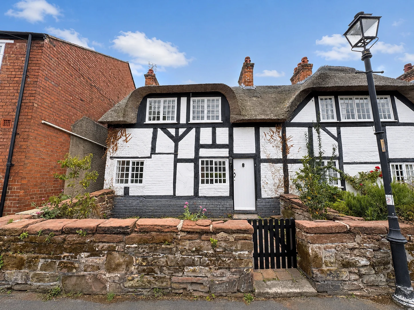 Black and white thatched cottage photographed by Whoopa